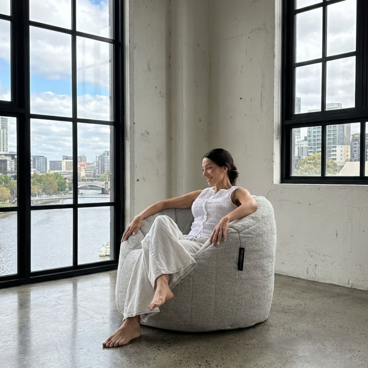 Butterfly Sofa in Alpine Mist — woman relaxing beside the window