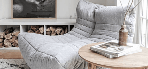 Grey bean bag sofa near fire place beside table