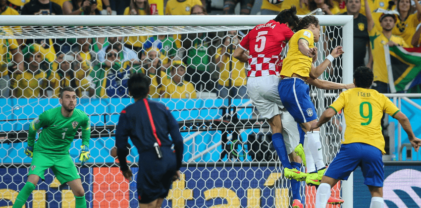 Brazil Soccer Players in yellow jersey tries to kick goal while Croatia in red jersey tries to block of the score in World Cup 2014