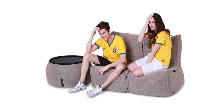 Couple watching football world cup sitting in a modular twin lounge set.